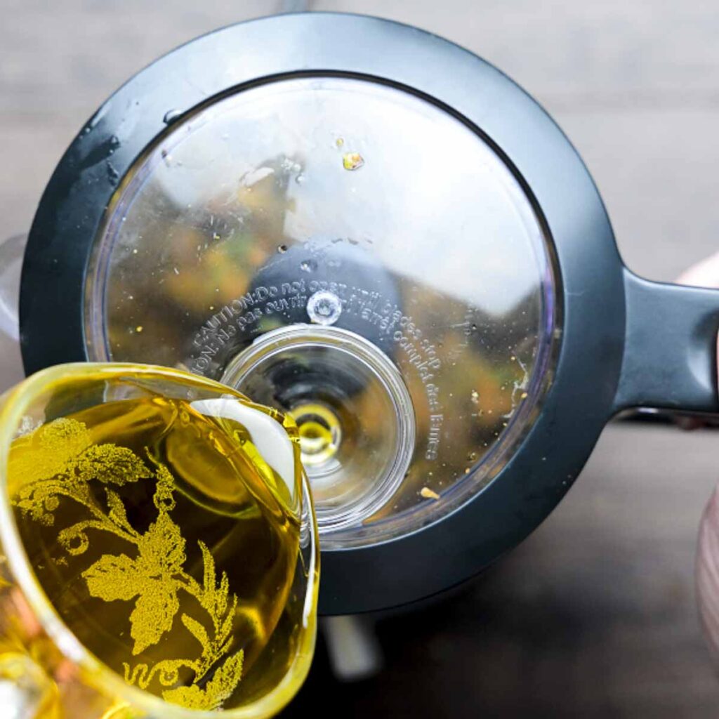Olive oil being added to a food processor.