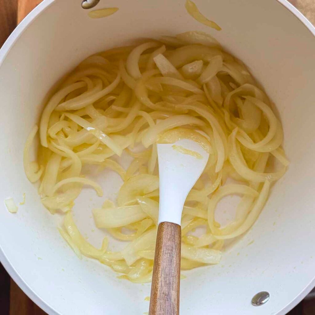 Onions sautéing as the first step in making Italian stewed peppers.