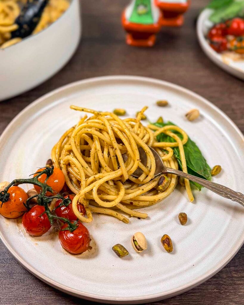 Pistachio pesto pasta from the top with pistachios, basil and blistered tomatoes.