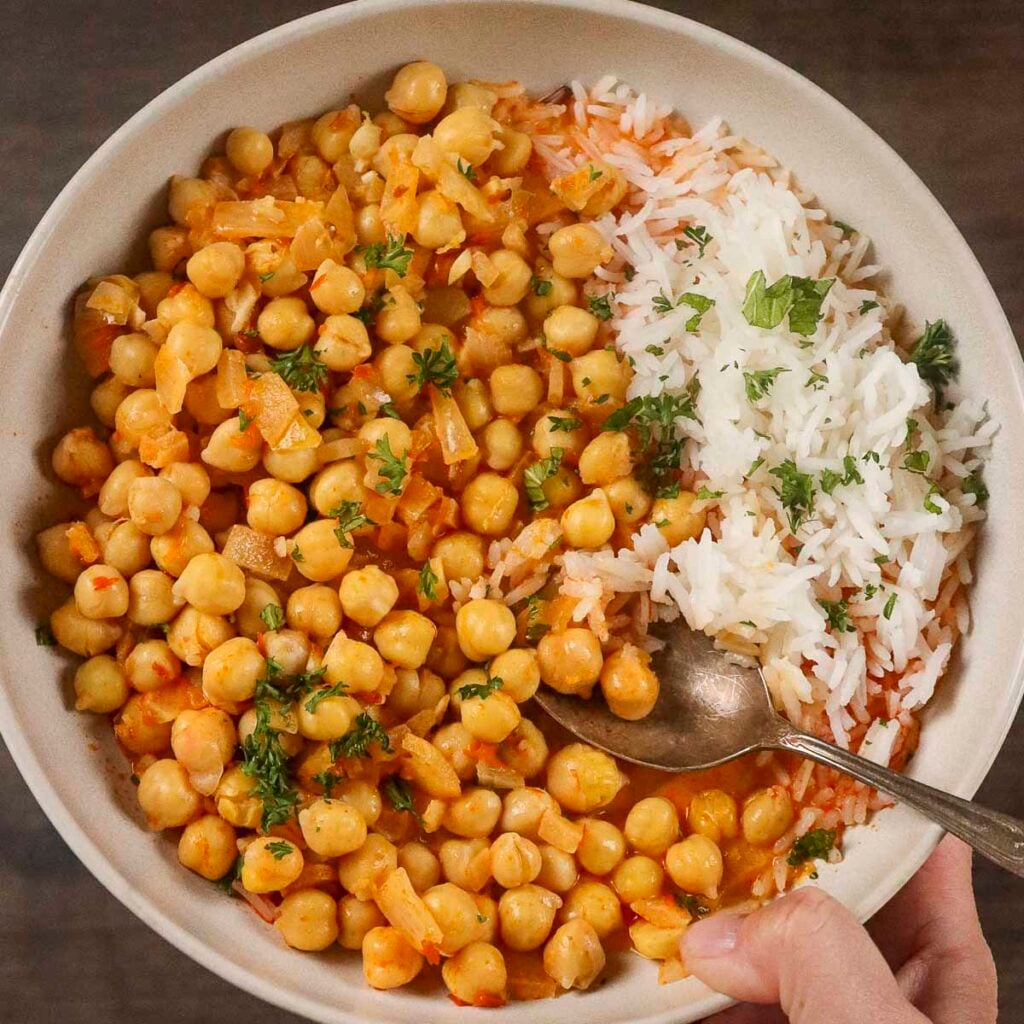 A bowl of filled with creamy harissa chickpeas and rice.