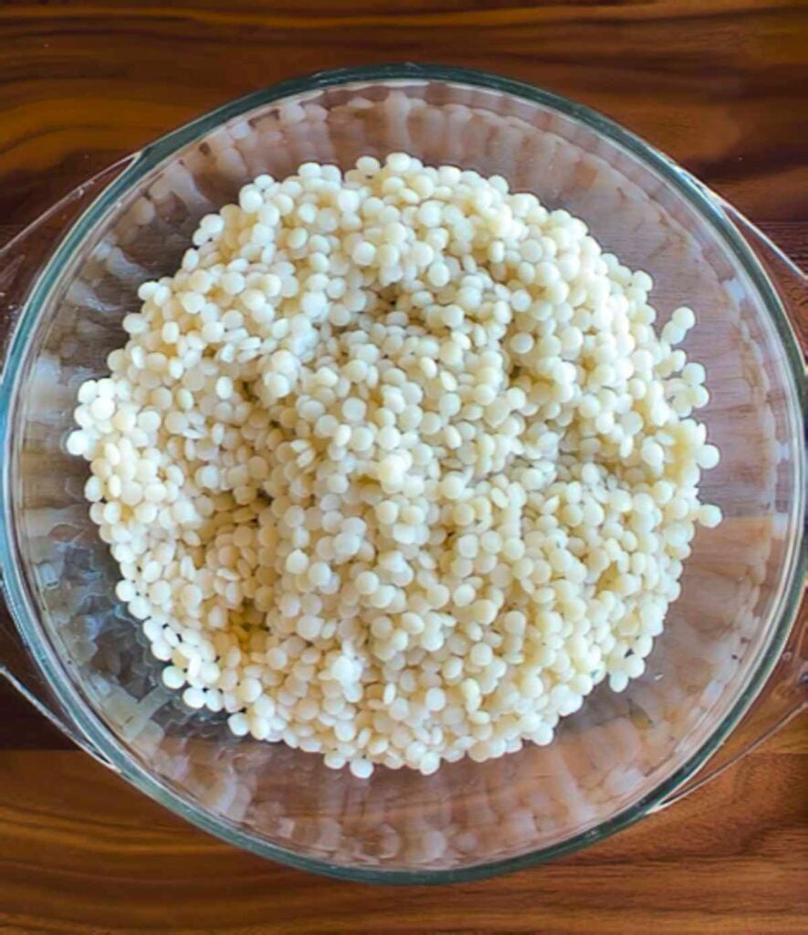 A glass bowl filled with one cup of cooked pearl couscous.