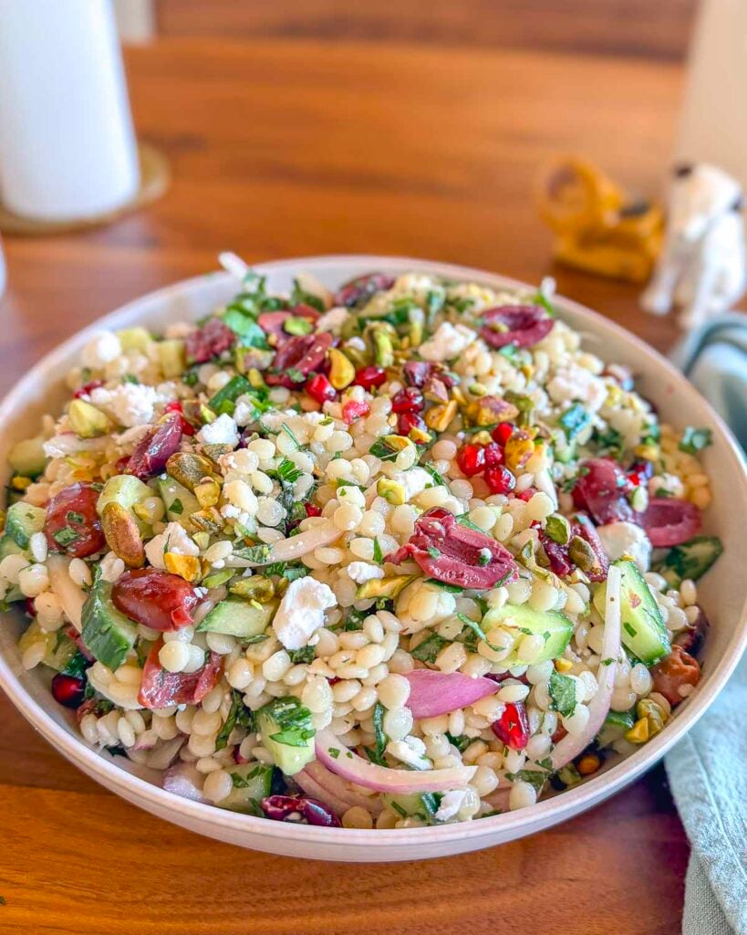 A plate with a couscous salad filed with Mediterranean ingredients.