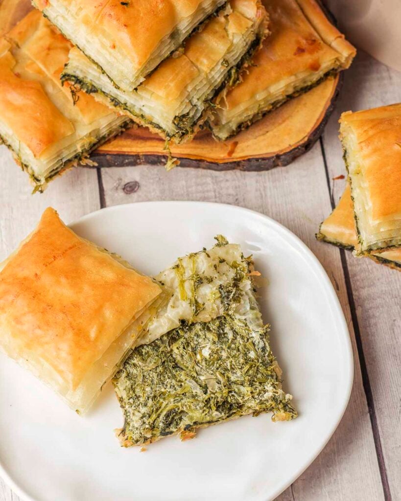 The inside of a slice of vegan spanakopita showing the cooked spinach filling.