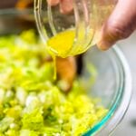 Ladolemono being poured on a maroulosalata (Greek lettuce salad)