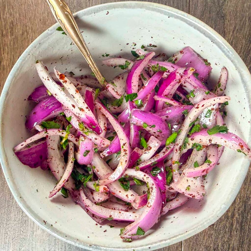 Sumac onions in a bowl right after all the ingredients have been mixed.