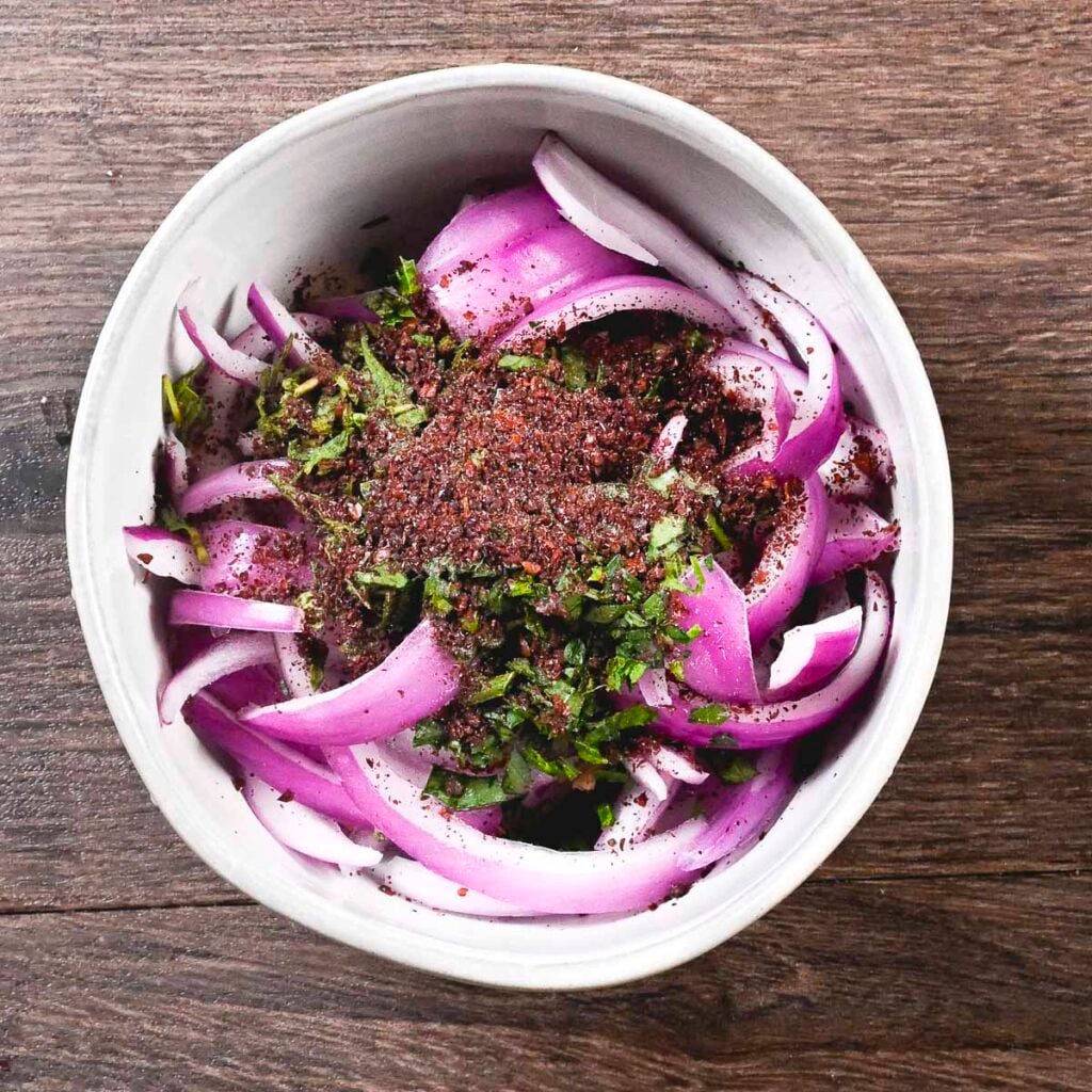 Sumac onions in a bowl right after all the ingredients are mixed.