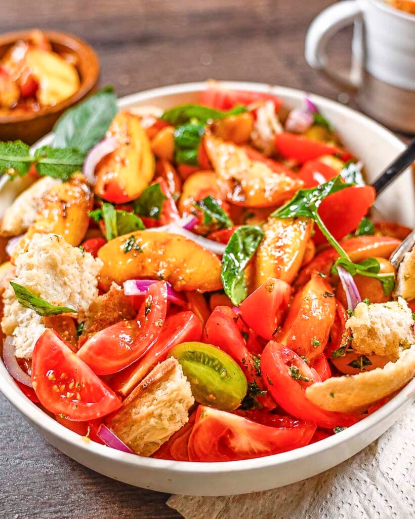 Grilled peach panzanella salad made with peaches, tomatoes, red onion, rustic bread and a lemon vinaigrette.