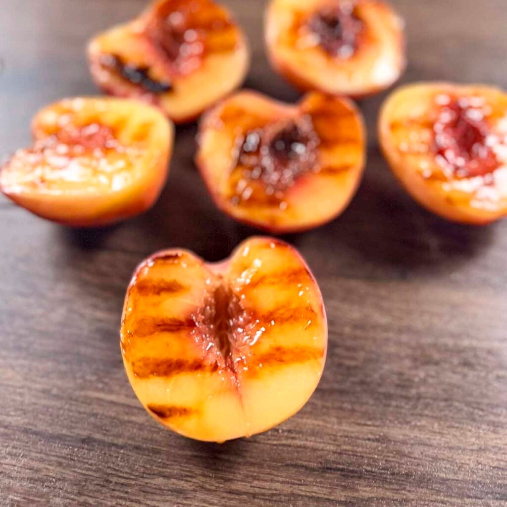 Grilled peach halves with visible grill marks.