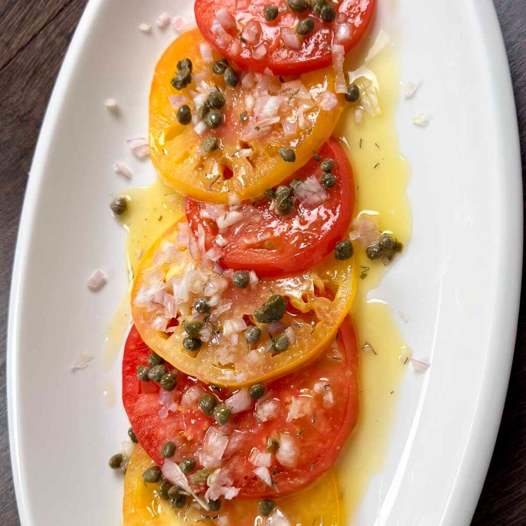 Marinated heirloom tomatoes topped with shallots and capers.