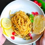 Overhead picture of Pasta alla Nerano on a plate being held by two hands.