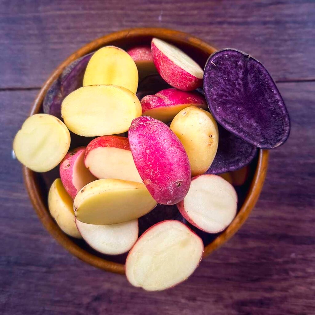 Sliced rainbow potatoes in a bowl.