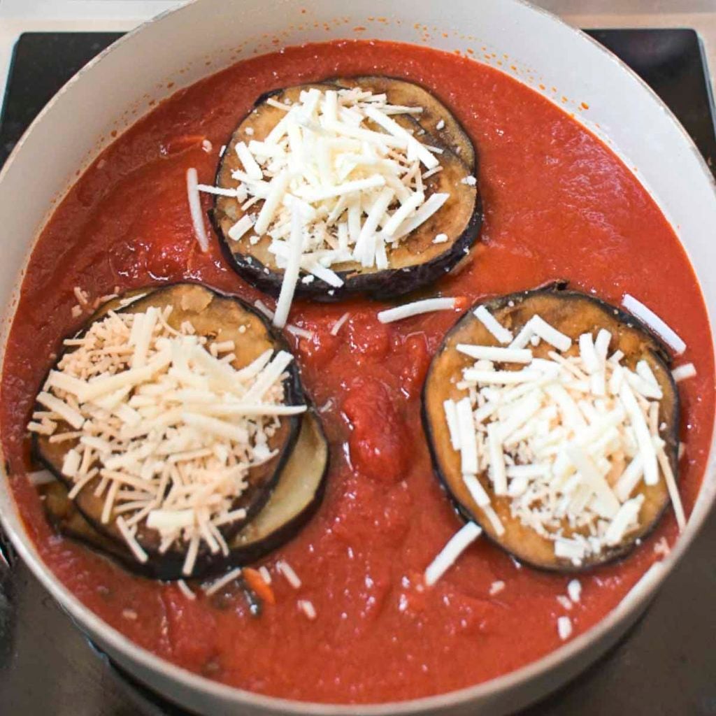 Stacks of skillet eggplant Parmesan in a skillet with San Marzano sauce.