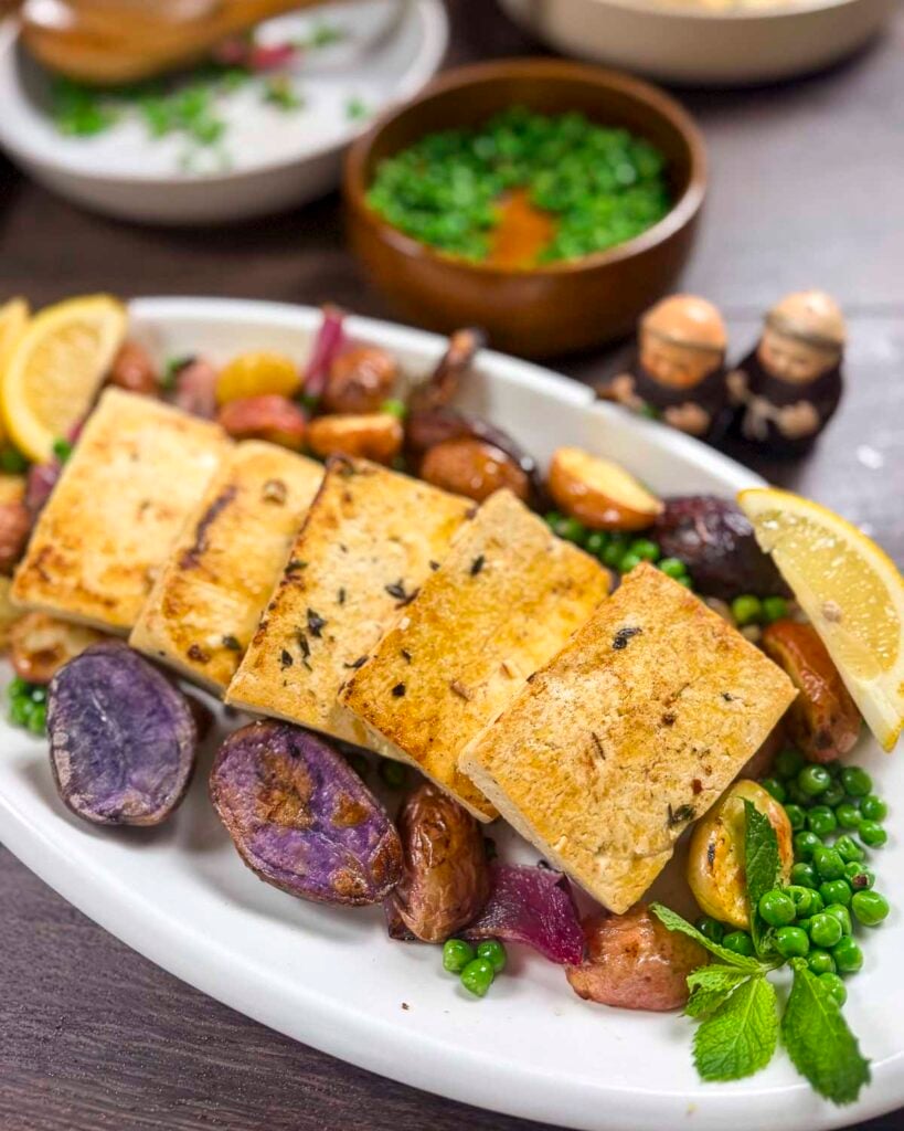A vegan family-style Greek dinner made with lemon oregano tofu, roasted new potatoes, and mint peas.