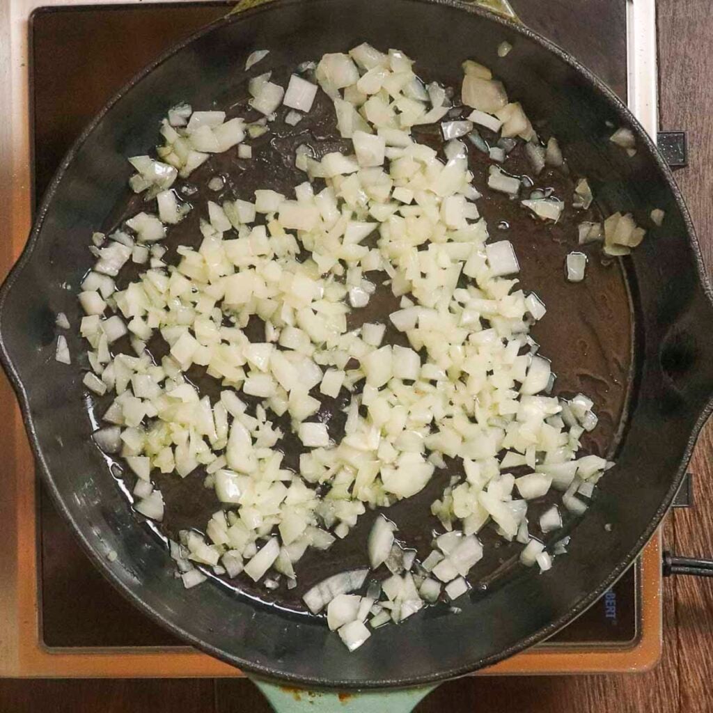 Onions sautéing in a cast iron skillet.