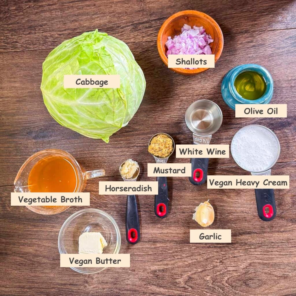 Ingredients used to make braised cabbage recipe (cabbage, shallots, olive oil, white wine, mustard, horseradish, vegetable broth, vegan butter, garlic, and vegan heavy cream.)