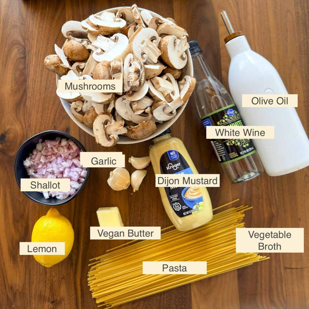 Ingredients used in making vegan mushroom pasta (mushrooms, shallot, lemon, vegan butter, garlic, Dijon mustard, white wine, olive oil, and vegetable broth).